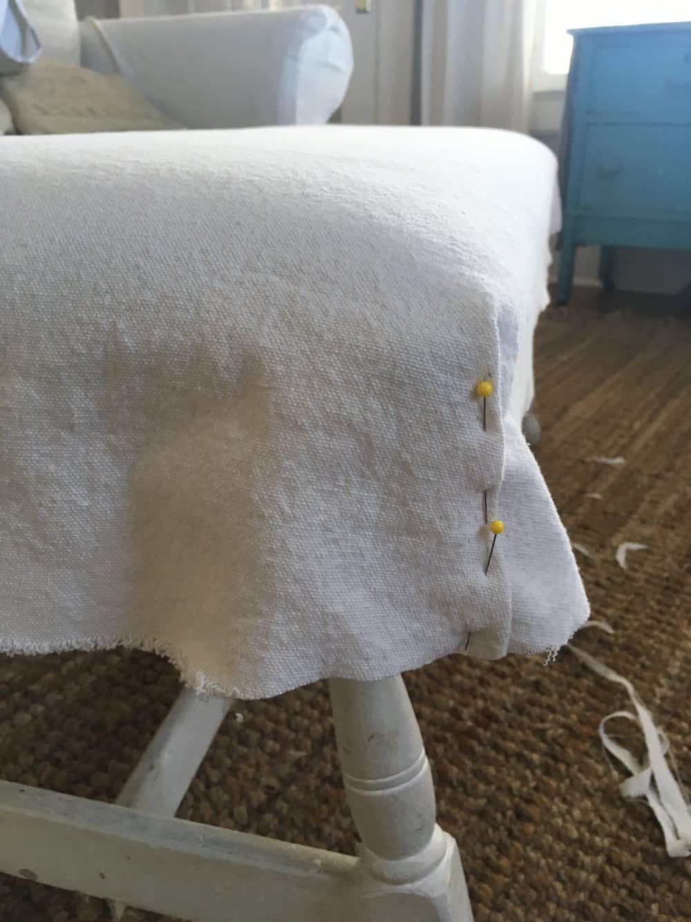 sides of drop cloth pinned to create bench slipcover
