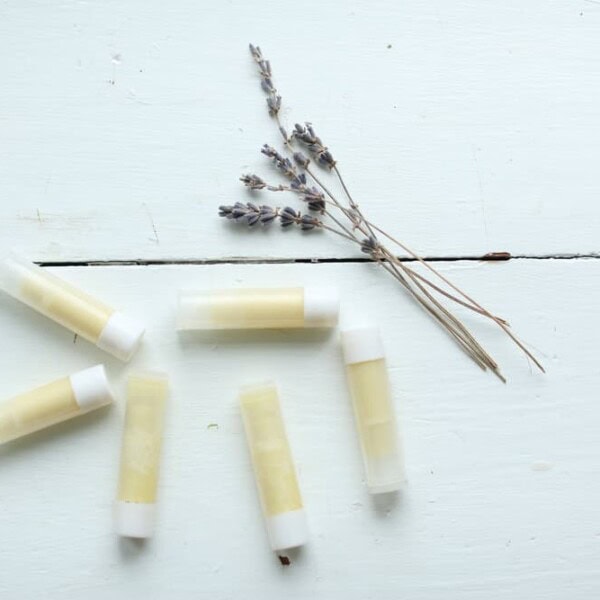 homemade lip balm on a white table with dried lavender