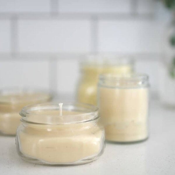 four beeswax candles on a white countertop