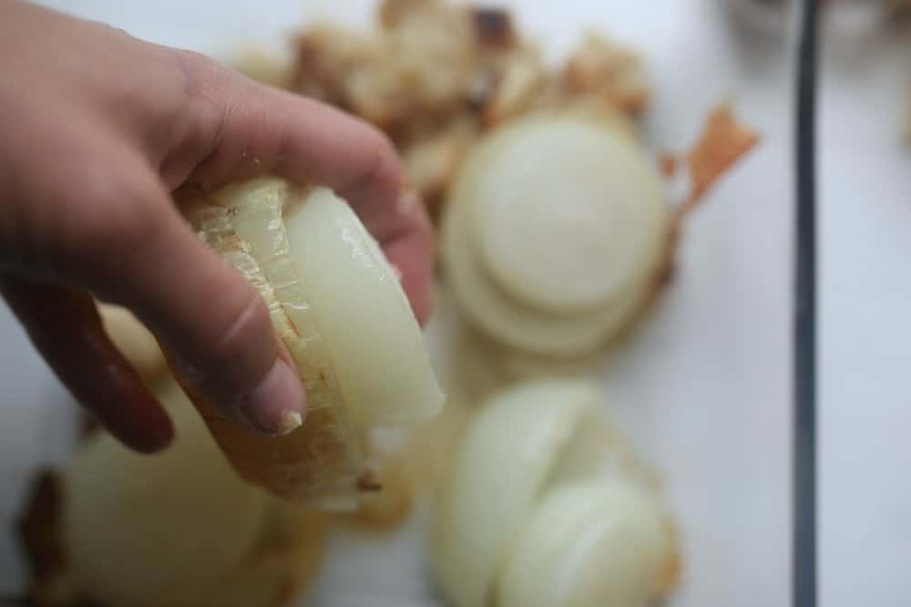 removing onion skins from roasted onions by squeezing