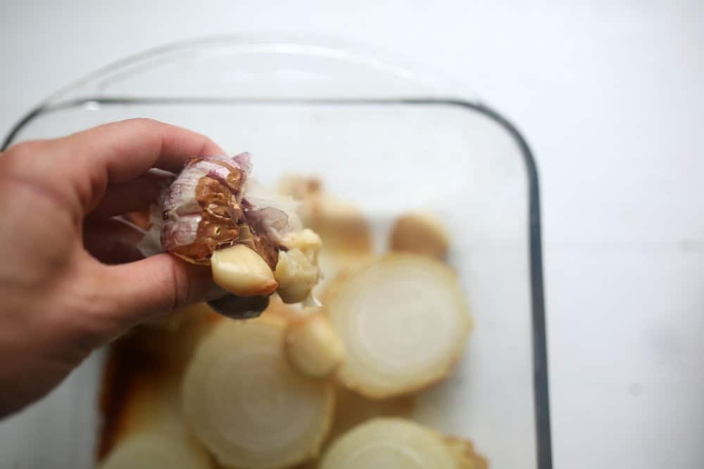 roasted garlic being squeezed