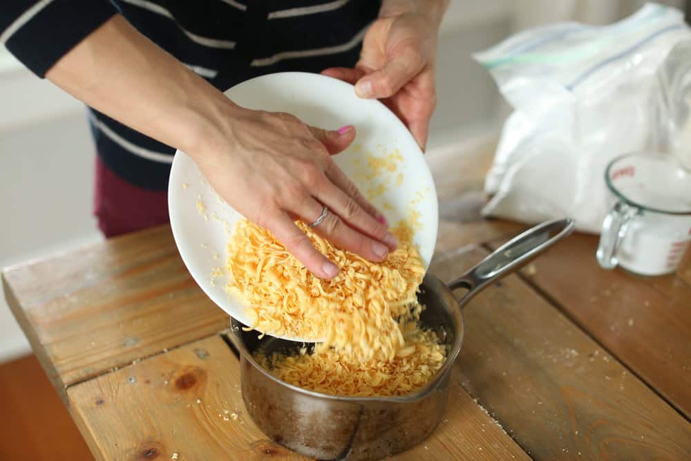 women adding plateful of grated Fels Naptha soap to a sauce pan with water