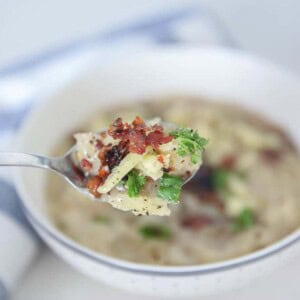 healthy potato soup in a white bowl with a spoonful of soup being lifted out of the bowl