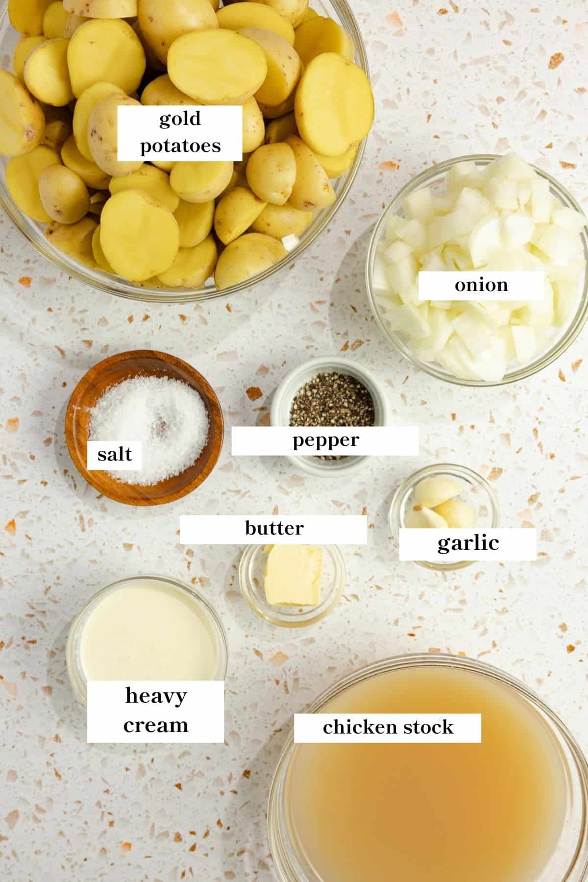 potatoes, broth, onion, garlic, and other ingredients on a countertop.