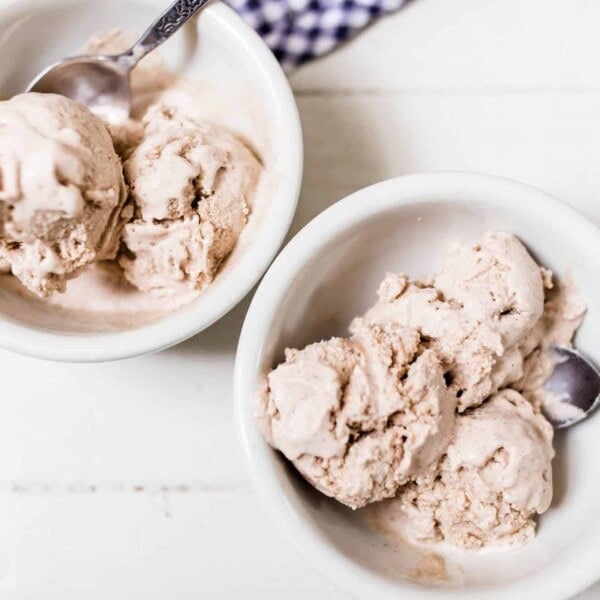 two bowls of pumpkin spice icecream on a white countertop with blue and white towel