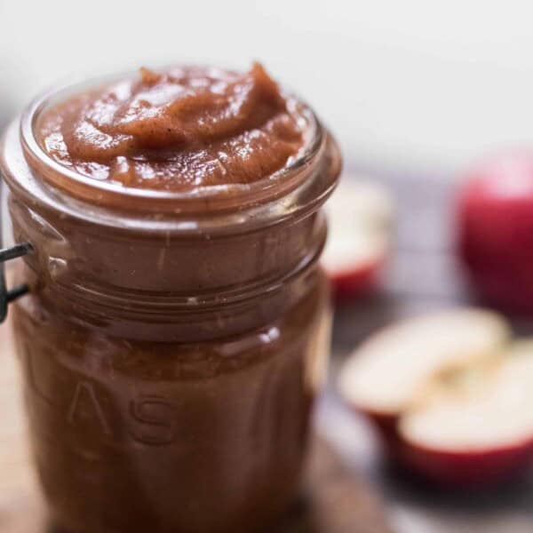 apple butter in mason jars with apples in the background