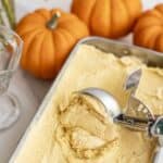 pumpkin ice cream being scooped out of a loaf pan.