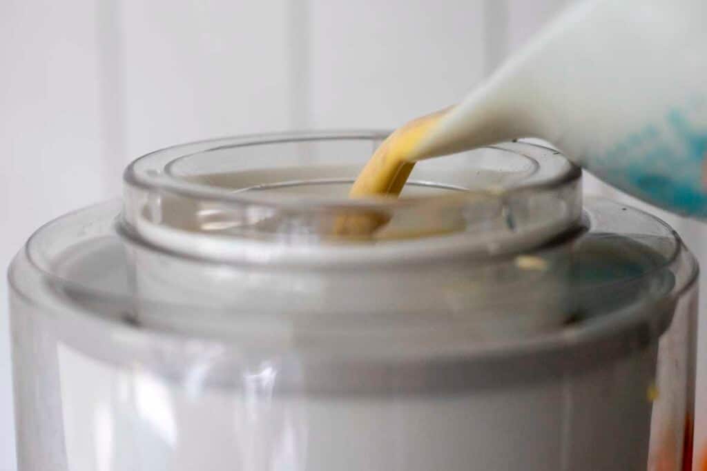 pouring ice cream mixture into ice cream maker.