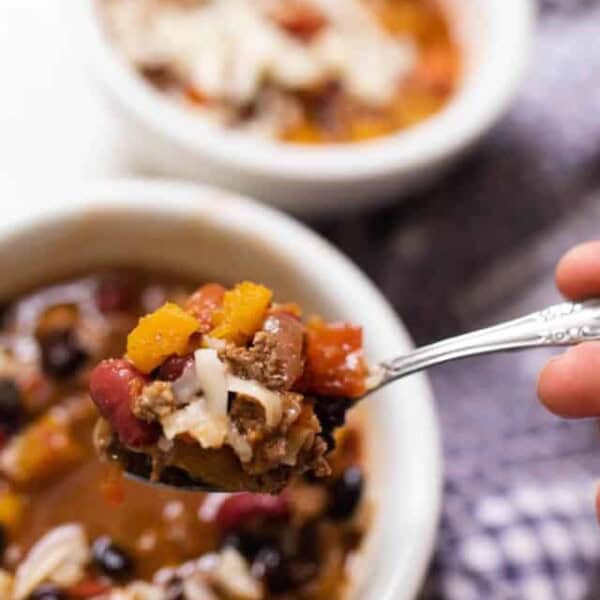 spoonful of pumpkin chili being raised up from the bowl