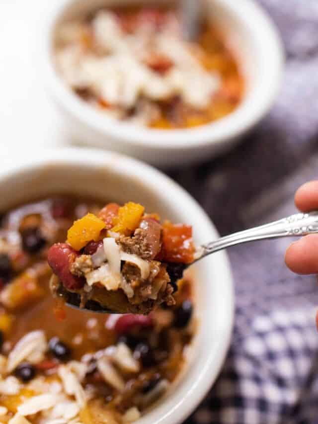 spoonful of pumpkin chili being raised up from the bowl