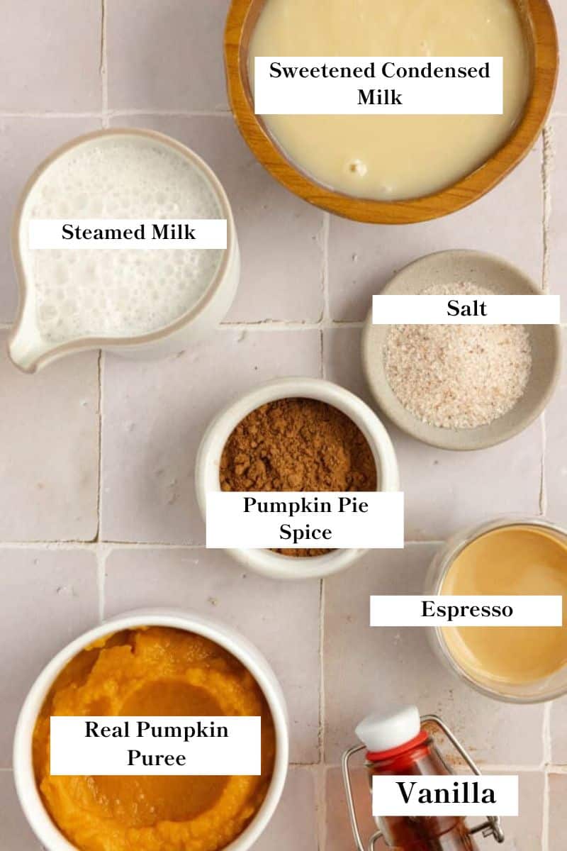 Ingredients for a pumpkin spice latte on a tile countertop. 