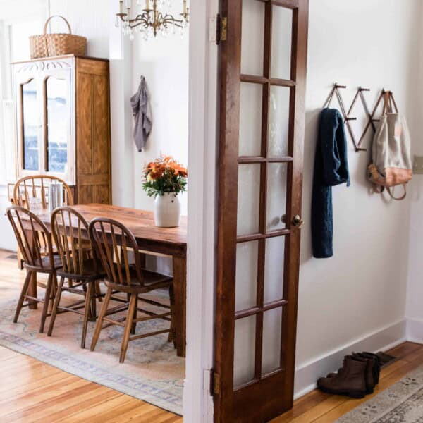 French doors to the eat-in kitchen are opened and showing gorgeous antique furniture