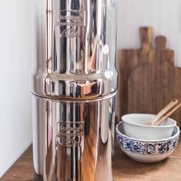 Berkey water filter system on a wood table with bowls and cutting boards in the background