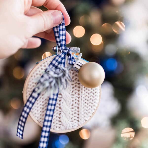 hand holding a Diy Christmas ornament made from embroidery hoop and a thrifted sweater