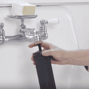 hand placing Black Berkey filter element onto running faucet to prime the filters