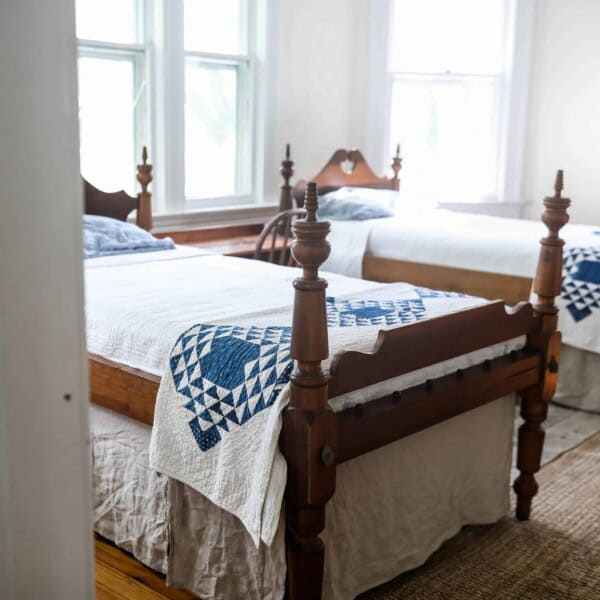 two antique wood beds with diy bed skirts made from linen