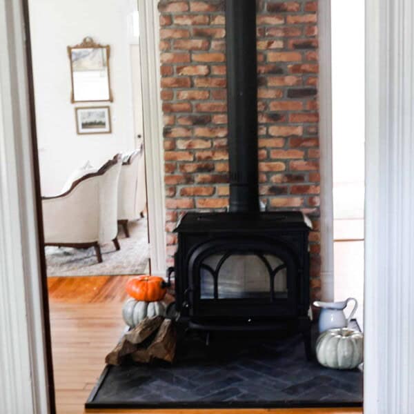 wood stove with a brick chimney and diy hearth pad with black slate