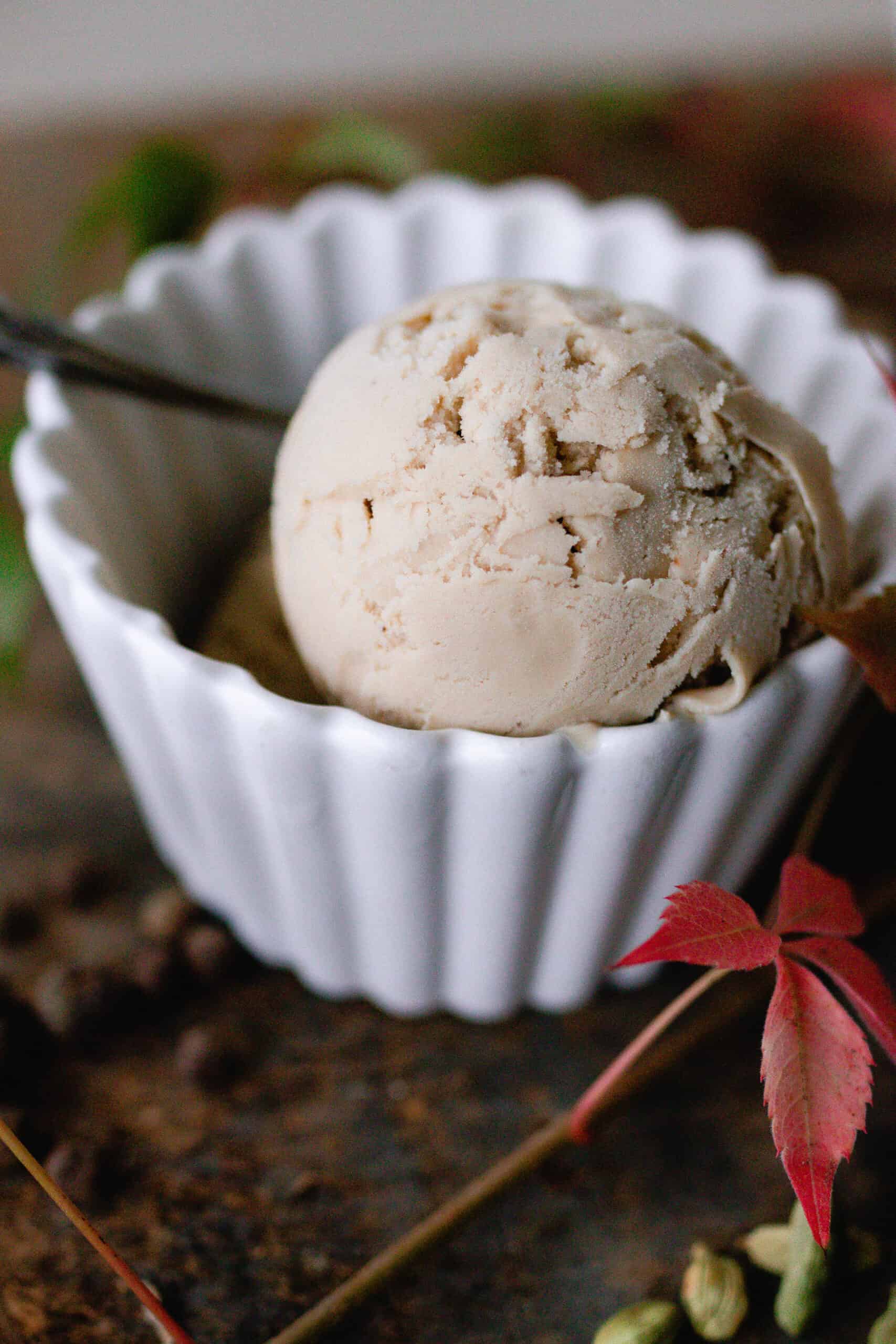 close up of a scoop of chai ice cream in a white bowl.