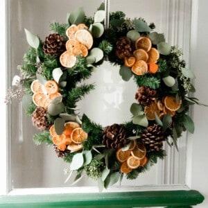 dried eucalyptus and orange wreath hanging ion a vintage door