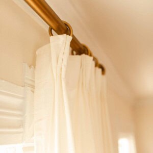 ikea rivta curtains hung with curtain clips on a brass rod