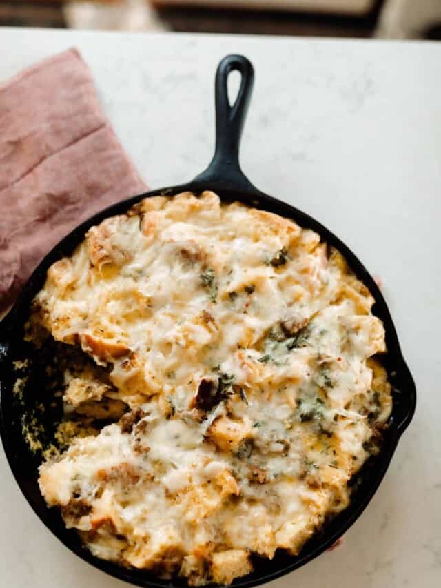 overhead photo of sourdough breakfast strata in a cast iron skillet on a red tea towel on a white quartz countertop