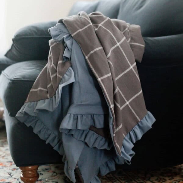 DIY flannel blanket with a ruffle on a blue couch