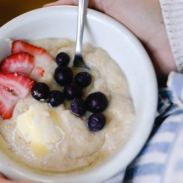 einkorn cream of wheat in a white bowl topped with blueberries and strawberries