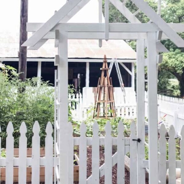 garden entrance with an arbor and a white picket fence - how to start a garden