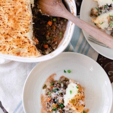 Cottage pie in a baking dish with servings on two white plates