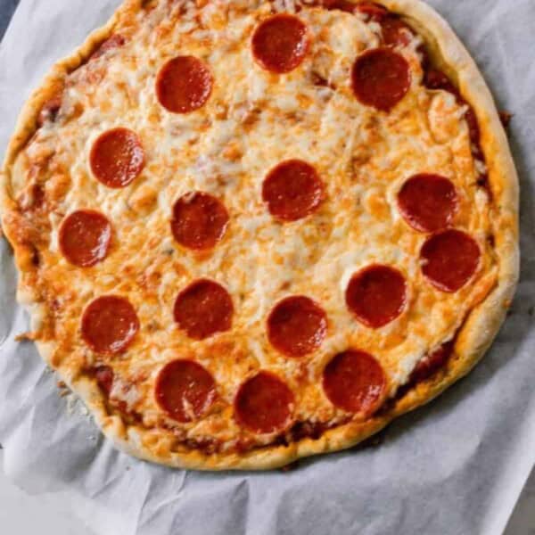 pepperoni pizza on an homemade einkorn crust on parchment paper.