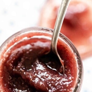 Jar of homemade strawberry ham sweetened with honey with a spoon in the har