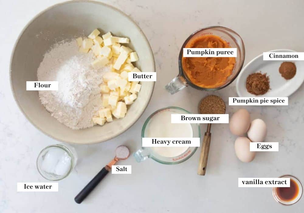 Ingredients of pumpkin pie on a white countertop. 