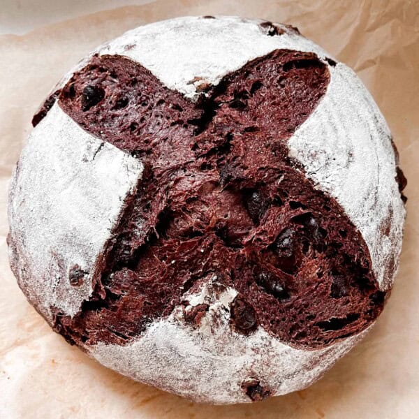 loaf of crust chocolate sourdough bread on parchment paper