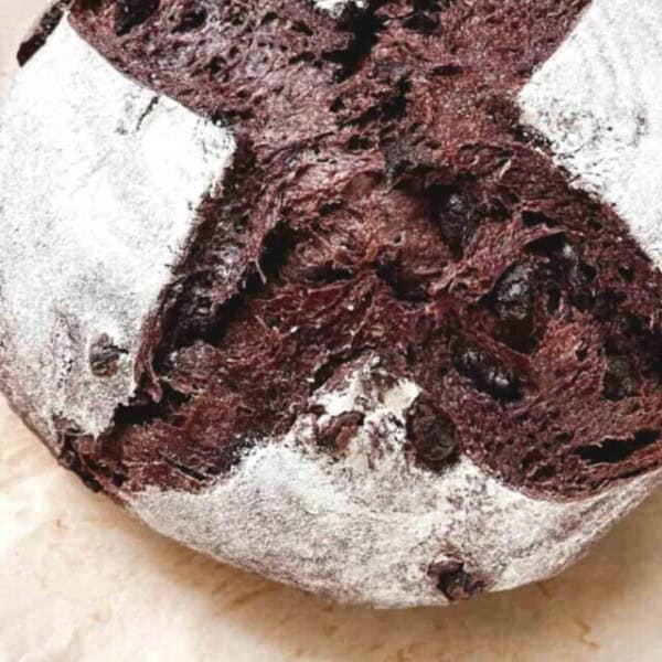 loaf of crust chocolate sourdough bread on parchment paper