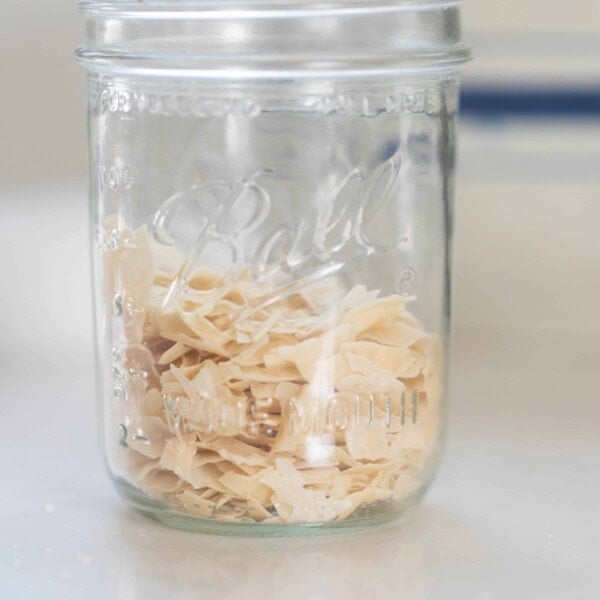 dry sourdough starter in a glass mason jar on a white countertop