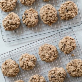 overhead photo os two wire racks full of sourdough oatmeal cookies on a white countertop