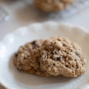 close up picture of two sourdough cookies on a white plate with scallop edge