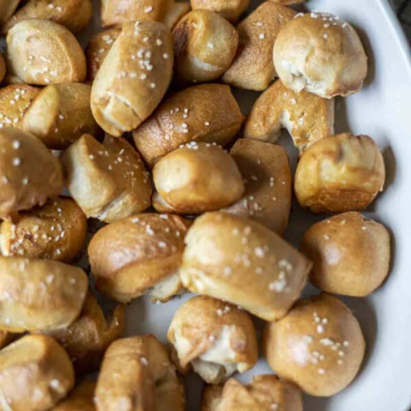 overhead photo of sourdough pretzel bites topped with course salt in a white enameled dish