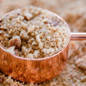 a copped and wood dry measuring up with sourdough breadcrumbs. The measuring cup rests on more bread crumbs