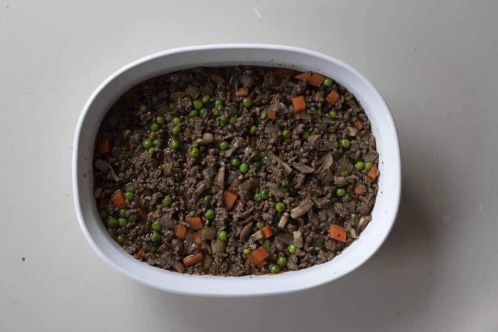 Shepherd pie pie filling in the bottom of a baking dish.