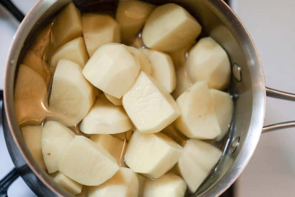 peeled and chopped potatoes in a saucepan.