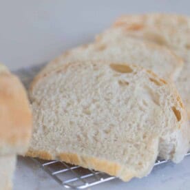 Slices of potato flake sourdough starter sandwich bread on a wire rack