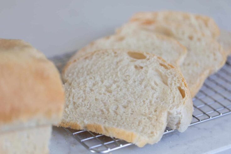 Slices of potato flake sourdough starter sandwich bread on a wire rack