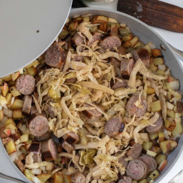 an aerial view of a large gray skillet filled with sausage and sauerkraut