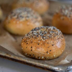 six sourdough discard bagels on a parchment lined baking sheet