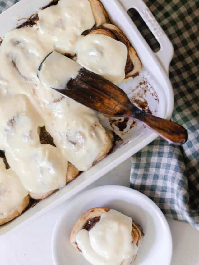 overhead photos of sourdough cinnamon rolls covered in a cream cheese icing in a white baking dish with a white plate with a cinnamon roll to the right