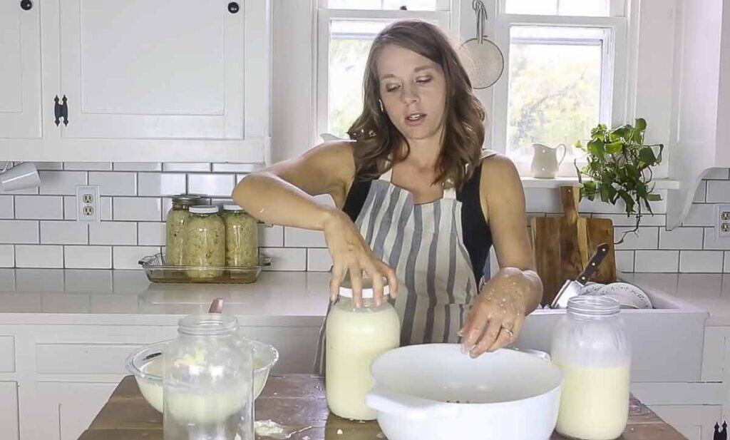 adding lid to a jar of milk and kefir grains.