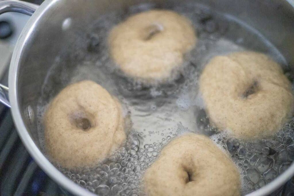 boiling bagels in a pot of water.