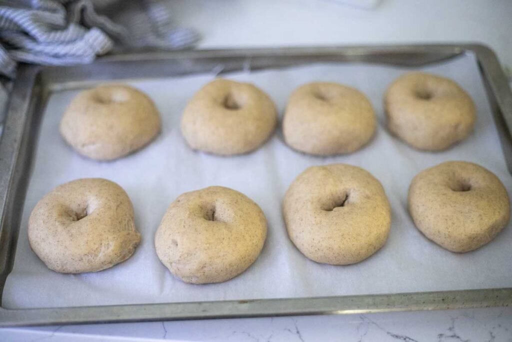 risen bagel dough on parchment paper.