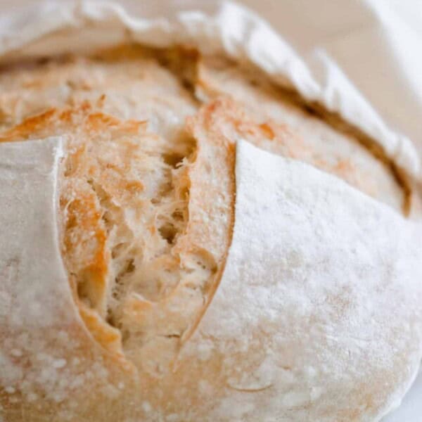 A sourdough loaf being placed in a linen bag